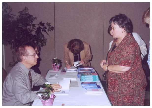 Dr. Krashen signs a book for middle school ESL teacher Elizabeth Park